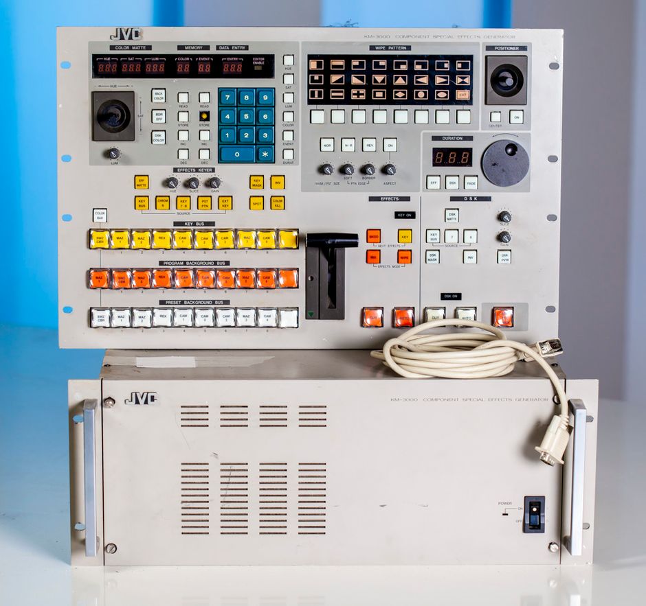 JVC KM-3000U Component Special-Effects Generator.

The KM-3000U Component Special-Effects Generator from JVC is a video processor designed to provide special-effects and processing features for component video signals. It can function as an 8-input component mixer, or inputs six through eight can also be used with RGB signals. It will output in (3) different signal formats: component, composite, and Y/C video.

Other features include a soft linear chroma key, an external key, and a luminance key. Automatic and manual transitions are both available. Special effects include downstream keys and fades, which can also be either automatic or manual. Transition time in automatic mode can be set between 0 and 999 frames with a rotary dial or 10-digit key pad. Moreover, (23) wipe patterns are included with the unit.

Color matte generation is offered for borders, background colors, and the downstream key. A built-in data memory can record up to (16) events and (24) colors. By leaving both the background and key switches on and actuating one extra effect, it is possible to mix 3-mode composite effects. It will interface with most RS-422 and GPI VCR editing controls.

Component Processing & Special Effects
Use this unit to process, mix, and add special effects to your component video signals.
Editing Features
Keying controls, automatic and manual transitions, and wipe patterns are just a few of the many standard features included with this unit.

Construction	Metal
Finish	Beige
Inputs	VIDEO INPUT
Program
(8) Y: 1.0Vp-p, 75 Ohms; R-Y/B-Y: 0.7Vp-p (100% color bar), 75 Ohms; R-Y/B-Y: 0.486Vp-p (75% color bar) with 7.5% setup) 75 Ohms
(2) Key VB: 0.7Vp-p, 75 Ohms
(1) external key VB: 0.7Vp-p, 75 Ohms or High
(1) external wipe VB: 0.7Vp-p, 75 Ohms or High
Genlock input
(1) B.b. VBS: 0.43 Vp-p, 75 Ohms or higher

Outputs	VIDEO OUTPUT
Program
(2) component Y: 1.0 Vp-p, 75 Ohms; R-Y/B-Y: 0.7Vp-p (100% color bar), 75 Ohms 0.486 Vp-p (75% color bar with 7.5% setup). 75 Ohms
(1) composite VBS: 1.0Vp-p, 75 Ohms
(1) Y/C output Y = 1.0Vp-p, 75 Ohms; C = 0.286Vp-p, 75 Ohms (burst level)
Preview
(1) component Y: 1.0 Vp-p, 75 Ohms; R-Y/B-Y: 0.7Vp-p (100% color bar), 75 Ohms 0.486 Vp-p (75% color bar with 7.5% setup), 75 Ohms
(1) composite VBS: 1.0Vp-p, 75 Ohms
(1) key hole BD: 0.7Vp-p, 75 Ohms
GENLOCK OUTPUT
(1) B.b. VBS: 0.43Vp-p, 75 Ohms or High Sync output
(3) B.B. VBS: 0.43Vp-p, 75 Ohms
FADER OUTPUT
(1) Fader DC voltage, 0 to 5VDC

Power	120 VAC, 50/60Hz, 95W (main unit), 28W (control unit)
Dimensions	Control unit: 5-15/16 x 19 x 12-1/4