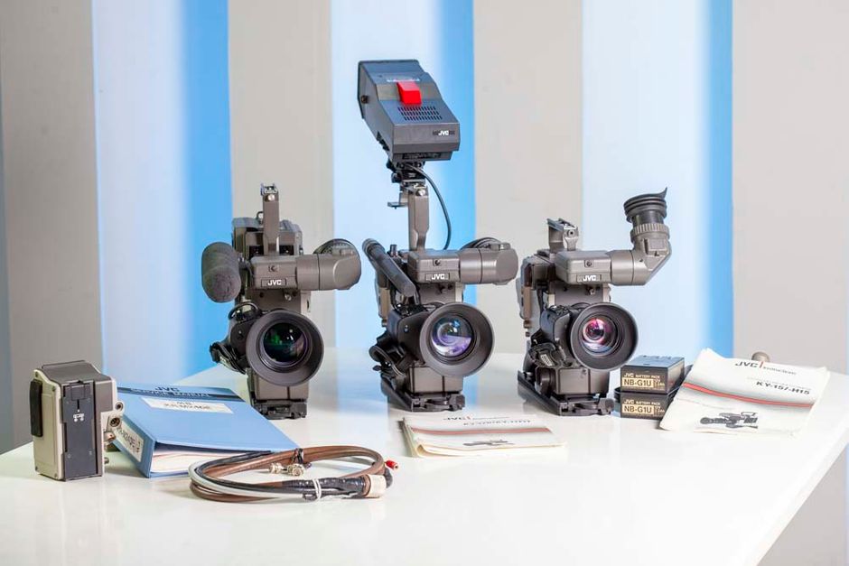 KY-15U THREE-CCD COLOR VIDEO CAMERA FEATURES

3 half-inch CCDs (330,000 pixels) with prism optical system
Excellent picture quality, 500 line resolution, 58dB s/n
Multi-format output compatible with M-II and S-VHS
Integrates with S-VHS portable for camcorder operation
RS-170A encoder for broadcast quality signal
High-speed electronic shutter
Stereo audio circuit
2H vertical contour correction, matrix masking circuit
Negative/positive image reversal circuit
Hot Shoe viewfinder and microphone connections


KY-15 THREE-CCD COLOR VIDEO CAMERA
In response to the demand for higher-quality visual images, JVC announced the development of the S-VHS format and has strived to introduce products of this format to the market. In doing so, the release of cameras which would perfectly match S-VHS recorders has been awaited.

Meanwhile, in the professional ENG camera market, cameras using solid-state pickup elements are becoming the mainstream, replacing those with tubes, because of their advantages in operability, size and weight. Also, cameras that can be used in the camcorder configuration are increasingly appreciated as they provide more mobility in newsgathering and field production.

The KY-15U series cameras, using 1/2